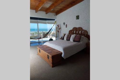 a bedroom with a large bed and a large window at CASA DE PLAYA EN ENSENADA in Ensenada
