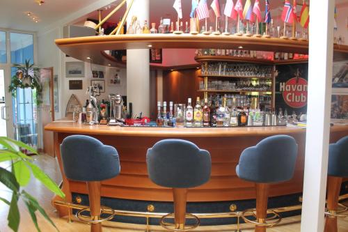 a bar with blue chairs in front of it at Hotel & Restaurant Zum Kap Arkona in Putgarten