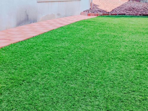 a yard of green grass next to a building at Kasuian in Kyoto
