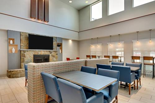 a waiting room with a table and chairs and a fireplace at Holiday Inn Express Hotel and Suites Weatherford by IHG in Weatherford