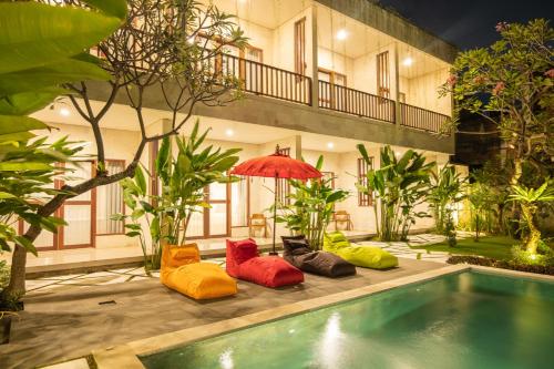 a group of pillows sitting next to a swimming pool at Mupu Jana G.House Keramas in Keramas