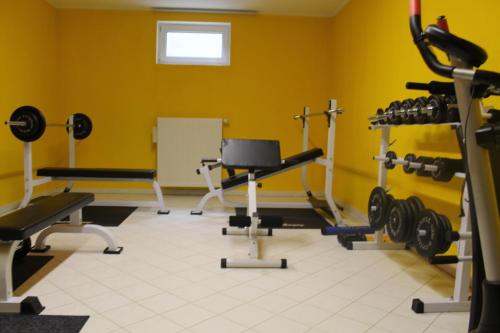 a gym with several tread machines in a yellow room at Hotel & Restaurant Zum Kap Arkona in Putgarten