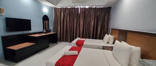 a hotel room with two beds and a television at Leisure Cove Hotel and Apartments in George Town