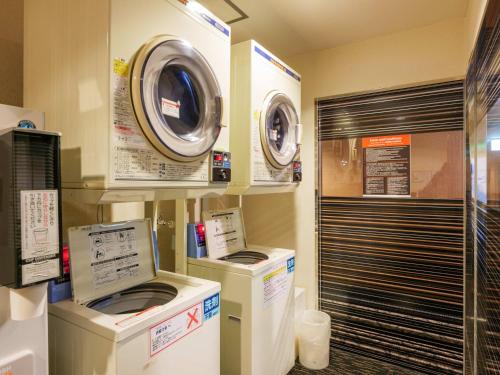 duas máquinas de lavar roupa e uma máquina de lavar e secar numa loja em APA Hotel Miyazaki Nobeoka Chuo em Nobeoka
