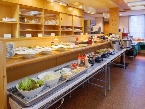 a buffet line with bowls of food on display at APA Hotel Miyazaki Nobeoka Chuo in Nobeoka