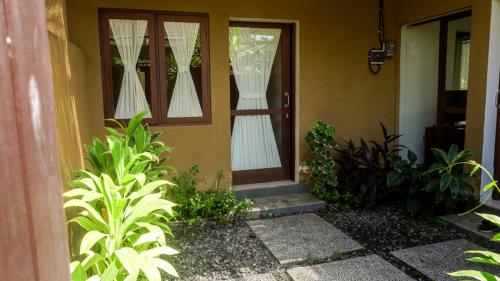 a house with a door with white curtains on it at The Janan Villa in Sanur