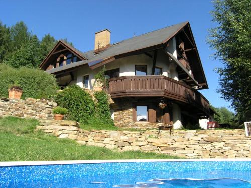 a large house with a swimming pool in front of it at Woodhouse in Rokytnice nad Jizerou