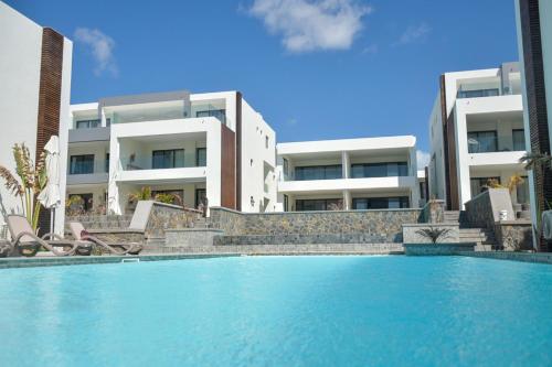 a swimming pool in front of a building at Eastern Blue - Sea View Luxury Apartment in Poste Lafayette