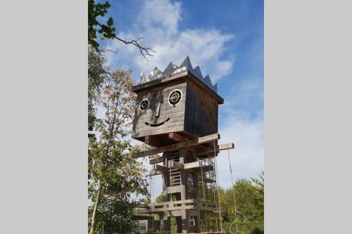 a tree house with a face drawn on it at Le Dom’Aisne à Zabeth, lieu simple et paisible *** in Chevregny