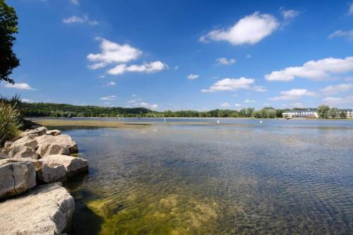 a large body of water with rocks in the foreground at Le Dom’Aisne à Zabeth, lieu simple et paisible *** in Chevregny