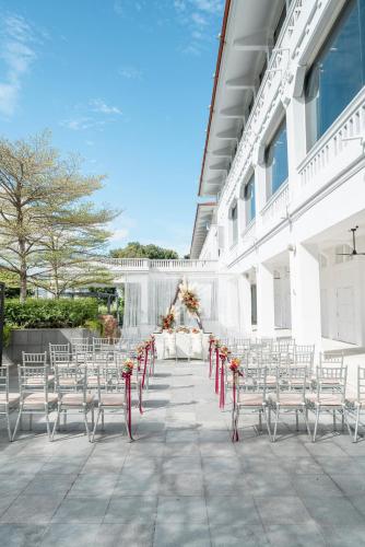a white table and chairs with a table and flowers at Oasia Resort Sentosa by Far East Hospitality in Singapore
