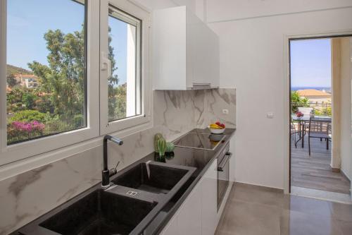une cuisine avec un évier et une fenêtre dans l'établissement Sea View Apartment, à Cap Sounion