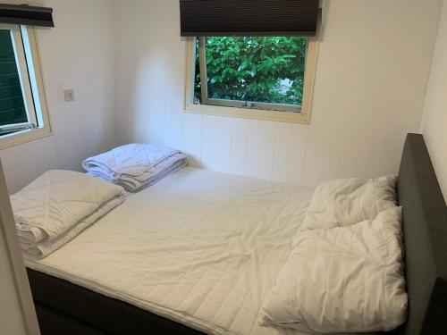 een bed in een kleine kamer met een raam bij Vakantiewoning (Chalet 52) in Putten