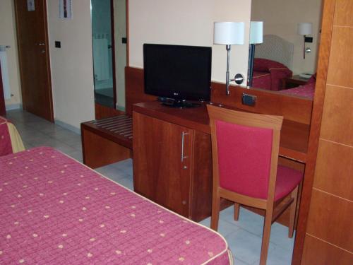 Cette chambre comprend une chambre avec un lit et une télévision. dans l'établissement Pisani Hotel, à San Nicola La Strada