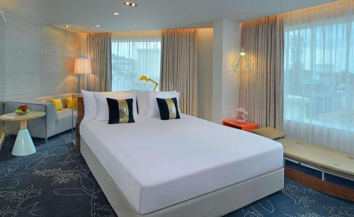 a bedroom with a large white bed and a couch at Radisson Bengaluru City Center in Bengaluru