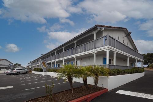 a large apartment building with a parking lot at Days Inn by Wyndham Arroyo Grande Pismo Beach in Arroyo Grande