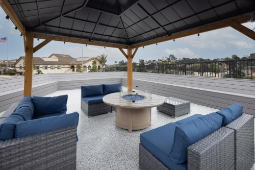 a patio with two blue couches and a table at Days Inn by Wyndham Arroyo Grande Pismo Beach in Arroyo Grande