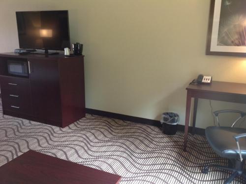 a room with a desk and a tv on a dresser at Executive Inn and Suites Jefferson in Jefferson