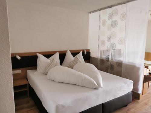 - un lit avec des oreillers blancs dans l'établissement Appartement Grafoner, à Sankt Anton am Arlberg