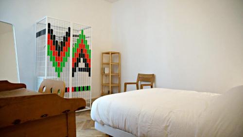 une chambre avec un lit et un tableau au mur dans l'établissement Little Suite - Marianne, à Lille