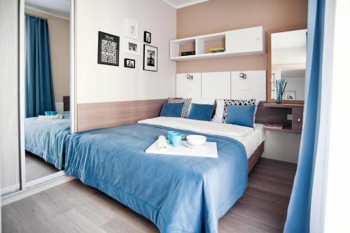 Habitación de hotel con 2 camas con sábanas azules en Apartament Luxon 2, en Kielce