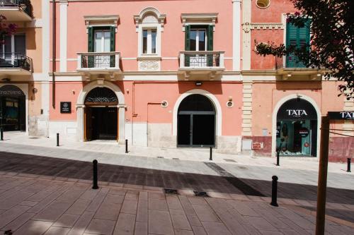 a pink building on a street in a city at Palazzo della Fontana in Matera