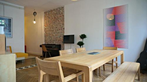 une salle à manger avec une table et des chaises en bois dans l'établissement Little Suite - Marianne, à Lille