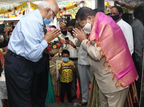 a man and a woman wearing a face mask standing next to a child at TM INN Hotel in Kanchipuram