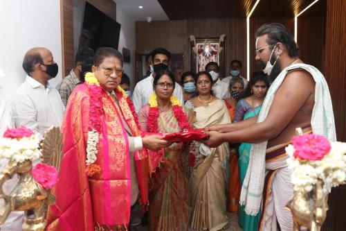 a man is handing a woman a red object at TM INN Hotel in Kanchipuram