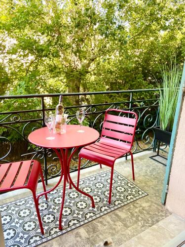 a red table and two chairs on a balcony at Chez Garance Saint-Tropez in Saint-Tropez