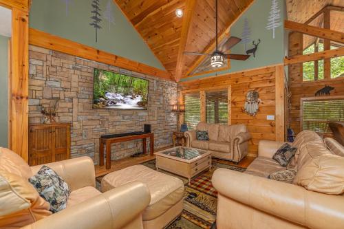 ein Wohnzimmer mit Ledermöbeln und einer Steinmauer in der Unterkunft Now and Forever cabin in Sevierville