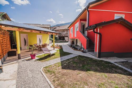 a backyard with red and yellow houses and a patio at CUDERLAND STUDIO KURNIK in Kobarid