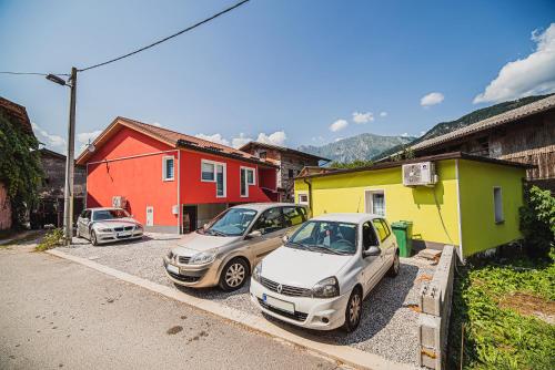 three cars parked in a parking lot next to houses at CUDERLAND STUDIO KURNIK in Kobarid