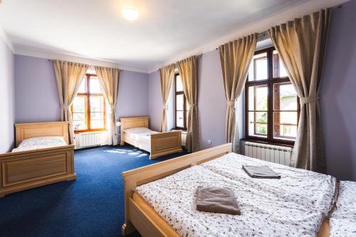 a bedroom with two beds and two windows at Penzion Johannes, Rýmařov - Stará Ves in Stará Ves