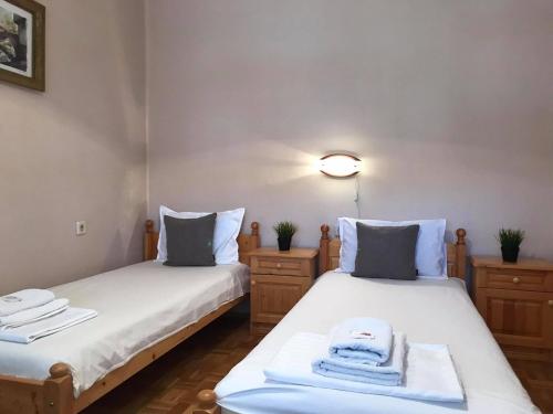 2 łóżka w małym pokoju z ręcznikami w obiekcie Къща за гости Загорски w mieście Kałofer