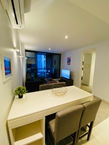 a kitchen and living room with a table and chairs at Flinders Street Apartments in Melbourne
