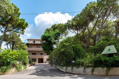 a house in the middle of a road with trees at Hotel Villa dei Pini in San Terenziano