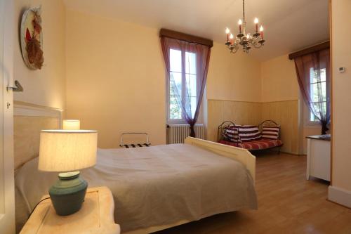 een slaapkamer met een bed en een lamp op een tafel bij Villa Rouvesol in Saint-Romain-de-Lerps