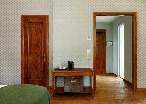 a bedroom with a bed and a table and a mirror at Schloss Fellin Boutique Hotel and Spa in Viljandi