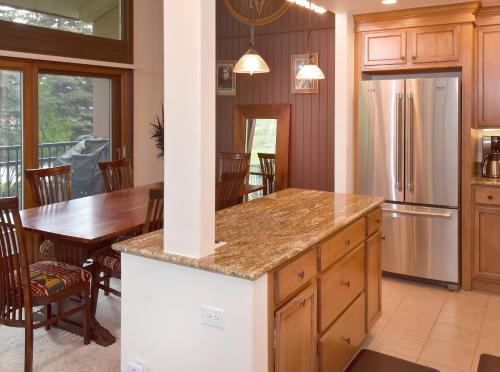 a kitchen and dining room with a table and a refrigerator at Vantage Point 210 Condo in Vail