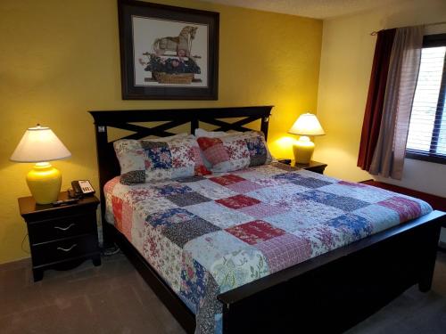 a bedroom with a bed with a quilt and two lamps at Wren 201 Condo with Vail Mountain View in Vail