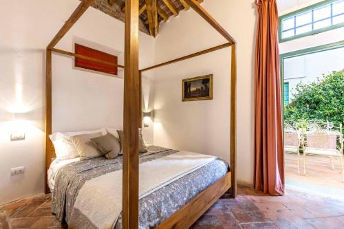 een slaapkamer met een hemelbed en een raam bij The Church Experience - San Miniato in Palagio