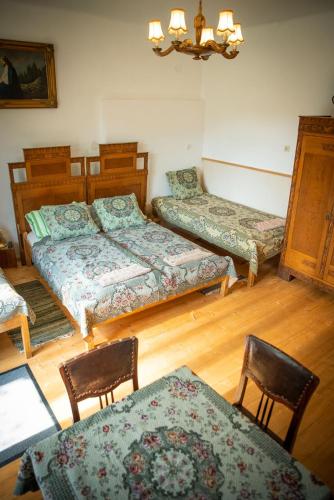 a room with two beds and two chairs and a table at Zempléni Szálláshely in Fony
