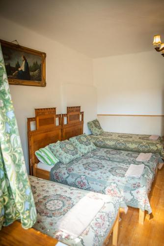 a bedroom with two beds and a picture on the wall at Zempléni Szálláshely in Fony