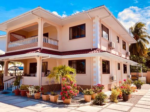 a house with potted plants in front of it at Erica's Self Catering Apartment in Mahe