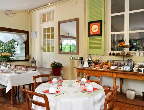 une salle à manger avec deux tables et des nappes blanches dans l'établissement Logis Hotel Villa Marjane, à Saint-Jean-le-Blanc