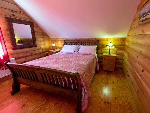a bedroom with a bed and a bench in a room at Eaglewood Lodge Connemara and Mayo in Carrowkennedy
