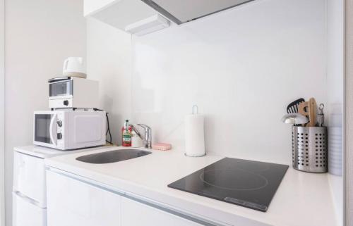 a kitchen counter with a microwave and a sink at Forest Yoyogi - Vacation STAY 20950v in Tokyo