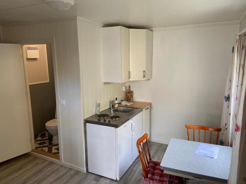 una pequeña cocina con fregadero y mesa en NyksundRom - small holiday flat, en Nyksund