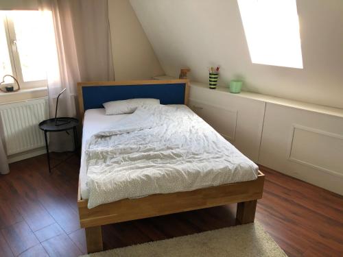 a small bedroom with a bed with a blue headboard at Haus Fink in Volkach